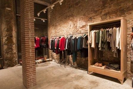 Remodelação de loja de roupa com parede em pedra à vista.
